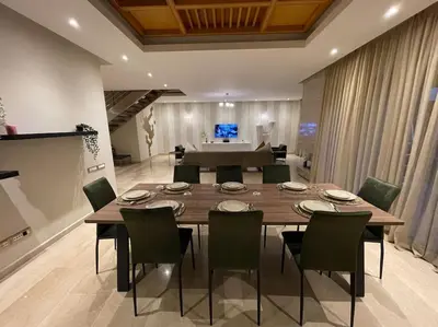 a dining room with a large wooden table and chairs at Luxury Villa Oasis, Bouznika Bay in Bouznika