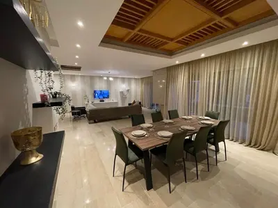 a dining room with a table and chairs and a couch at Luxury Villa Oasis, Bouznika Bay in Bouznika