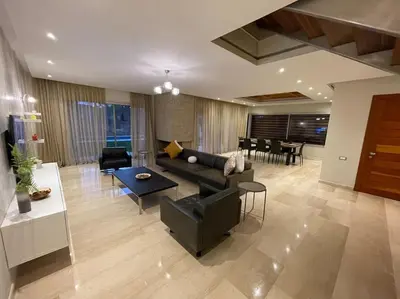 a living room with a couch and a table at Luxury Villa Oasis, Bouznika Bay in Bouznika
