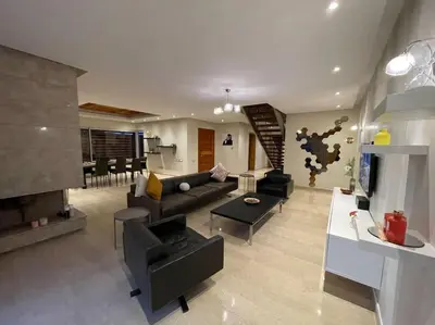 a living room with a couch and a fireplace at Luxury Villa Oasis, Bouznika Bay in Bouznika