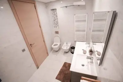 a bathroom with two toilets and a sink and a mirror at Luxury Prestigia 2Bed Rooms in Rabat
