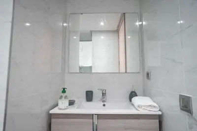 a white bathroom with a sink and a mirror at Luxury Prestigia 2Bed Rooms in Rabat