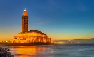 a large building with a clock tower at night at Appartement Ocean View - Marina Casablanca in Casablanca
