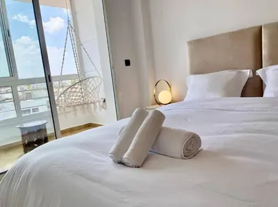 a bedroom with a white bed with towels on it at Appartement au cœur de Rabat in Rabat