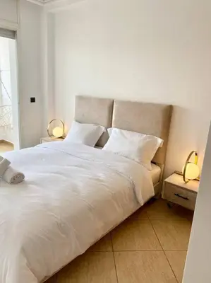 a bed with white sheets and pillows in a bedroom at Appartement au cœur de Rabat in Rabat