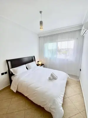 a white bed in a room with a window at Appartement au cœur de Rabat in Rabat