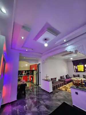 a living room with purple ceilings and a couch at chez Jalil in Aïn ej Jmel