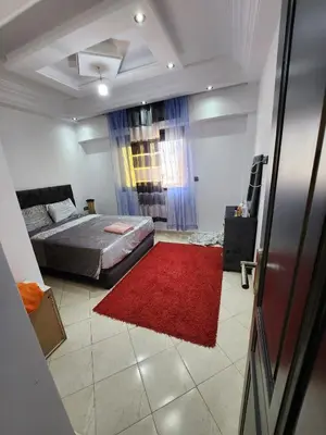 a bedroom with a bed and a red rug at chez Jalil in Aïn ej Jmel