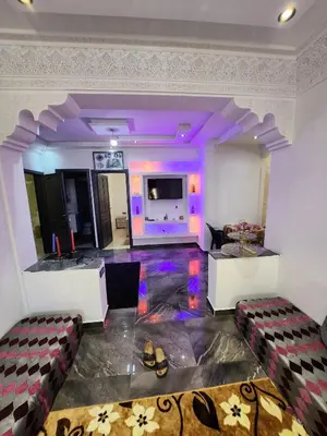 a living room with purple lighting and a tv at chez Jalil in Aïn ej Jmel