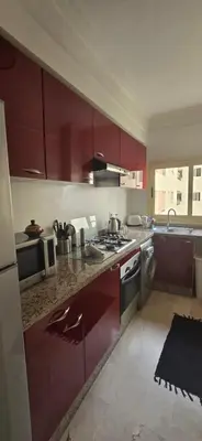 a kitchen with red cabinets and a stove top oven at Horizon Appartement Playa in Casablanca