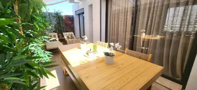 a wooden table and chairs in a room with plants at Sky View Casa- 2 Bed rooms au coeur du Maarif in Casablanca