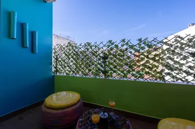 a room with a fence and a table and stool at Pop Art Studio-Location Journalière Casablanca in Casablanca