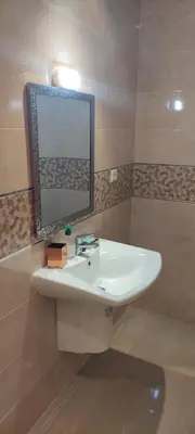 a bathroom with a white sink and a mirror at APPARTEMENT haut standing in O Ben Slimane