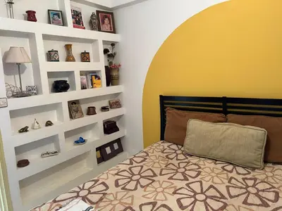 a bedroom with a bed with white shelves at Apparemment déjà vendu ne réserve pas in Azemmour