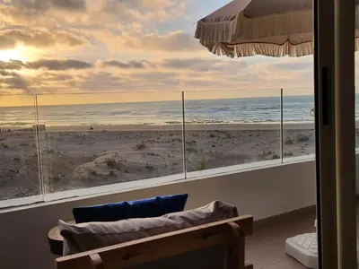 a room with a view of the beach from a window at Sidi Rahal Blue View, Beachfront wide seaview with pool in Sidi Rahal