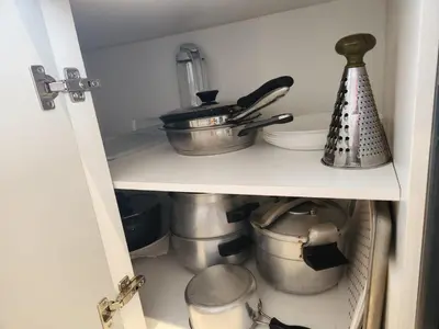 a cabinet filled with pots and pans in a kitchen at Sidi Rahal Blue View, Beachfront wide seaview with pool in Sidi Rahal