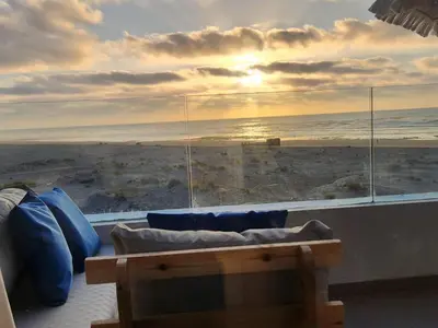 a living room with a couch and a view of the ocean at Sidi Rahal Blue View, Beachfront wide seaview with pool in Sidi Rahal