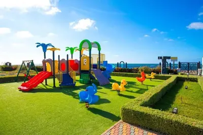 a park with a playground with ducks on the grass at Appartement Casablanca in Dar Bouazza