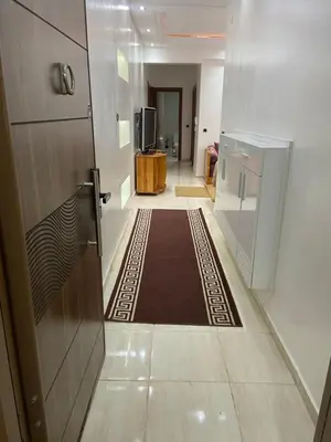 a hallway with a door and a rug on the floor at Appartement avec suite parentale in Mohammedia