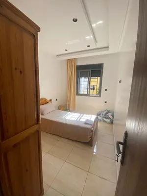 a bedroom with a bed and a window at Appartement avec suite parentale in Mohammedia