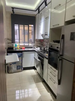 a kitchen with white cabinets and a refrigerator at Appartement avec suite parentale in Mohammedia