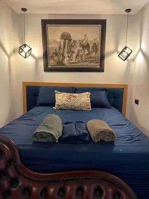 a bed with two pillows and a painting on the wall at La perle corniche in Casablanca
