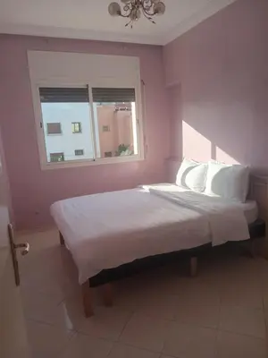 a bedroom with a bed with white sheets and a window at Appartement HASSANIA in Casablanca