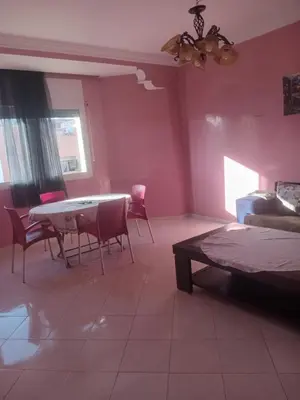 a bedroom with pink walls and a table and chairs at Appartement HASSANIA in Casablanca