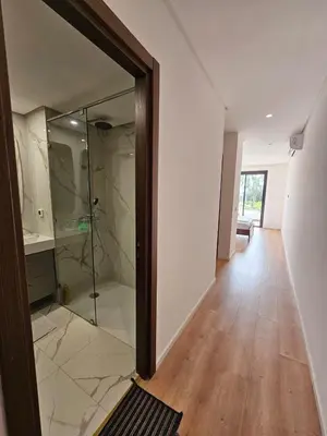 a bathroom with a glass shower in a room at Superbe Appartement Green Town in Oulad Lahsene