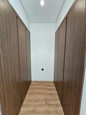 a corridor with wooden doors in a room at Superbe Appartement Green Town in Oulad Lahsene