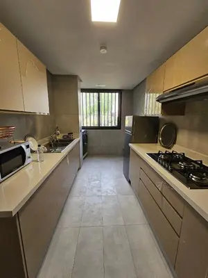 a large kitchen with a stove and a sink at Superbe Appartement Green Town in Oulad Lahsene