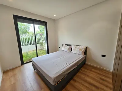 a bedroom with a bed with a large window at Superbe Appartement Green Town in Oulad Lahsene