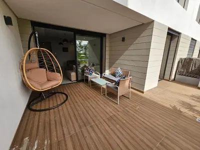 a porch with a chair and a swing on a house at Superbe Appartement Green Town in Oulad Lahsene