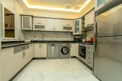 a kitchen with white cabinets and a refrigerator at Laura Residence in Bouznika