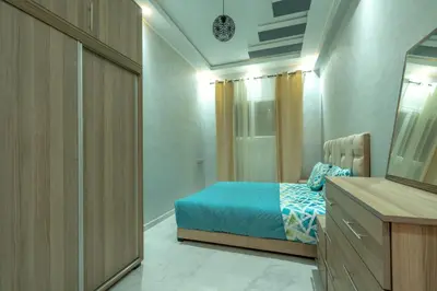 a bedroom with a bed and a dresser with a mirror at Laura Residence in Bouznika