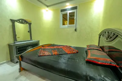 a bed with two pillows and a mirror in a bedroom at Laura Residence in Bouznika