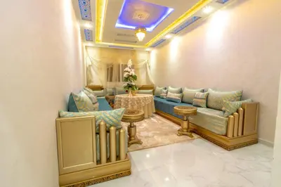 a living room with a blue couch and a table at Laura Residence in Bouznika