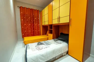 a small bedroom with yellow cabinets and a bed at Laura Residence in Bouznika