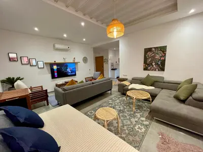 a living room with couches and a flat screen tv at Au Cœur Des Sables D’or - Harhoura in Temara