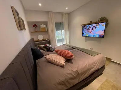 a bedroom with a bed and a flat screen tv at Au Cœur Des Sables D’or - Harhoura in Temara