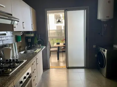 a kitchen with a door leading to a dining room at Au Cœur Des Sables D’or - Harhoura in Temara