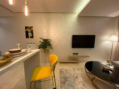 a living room with a table and a yellow chair at Glamorous Habous - By AppartAli in Casablanca