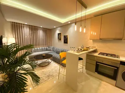 a kitchen and living room with a couch and a table at Glamorous Habous - By AppartAli in Casablanca