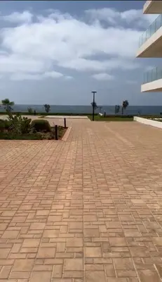 a brick walkway with the ocean in the background at Le Carrousel Appartement in front of the see in Rabat