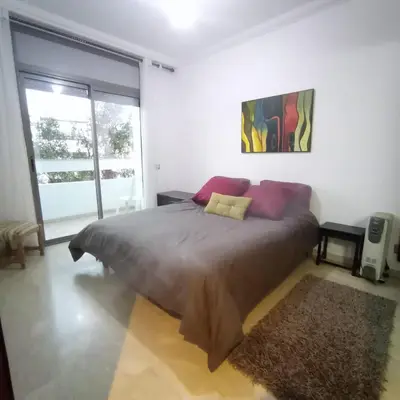 a bedroom with a large bed and a large window at Bel appartement à skhirat plage et à 20 mn de Rabat in Skhirat