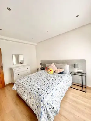 a bedroom with a large bed with aokedokedokedoked at Appartement Cozy au Triangle d’or in Casablanca