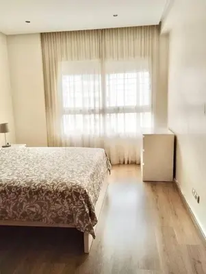 a bedroom with a bed and a large window at Appartement Cozy au Triangle d’or in Casablanca