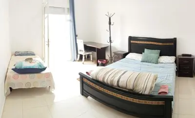 a bedroom with a bed and a desk in it at Maison indépendante 100m2 à Témara centre in Temara