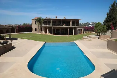 a house with a swimming pool in front of a house at Villa Tizra - Guest house in AÃ¯n el Ksob