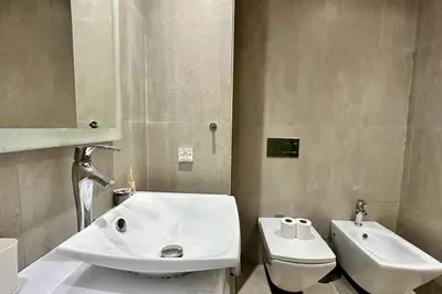 a white bathroom with a sink and a toilet at Marina State of Peace - Sea View in Casablanca